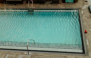 Top view of an empty outdoor swimming pool at a hotel, ideal for summer vacations.